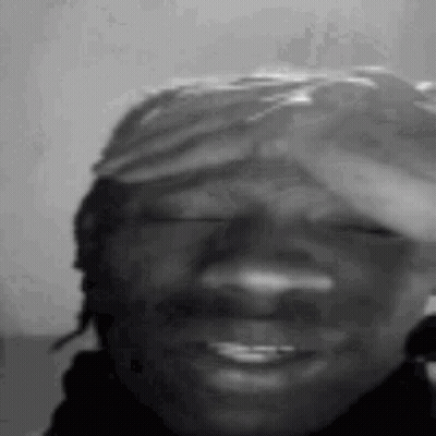 A Black And White Photo Of A Man Wearing A Bandana On His Head . GIF