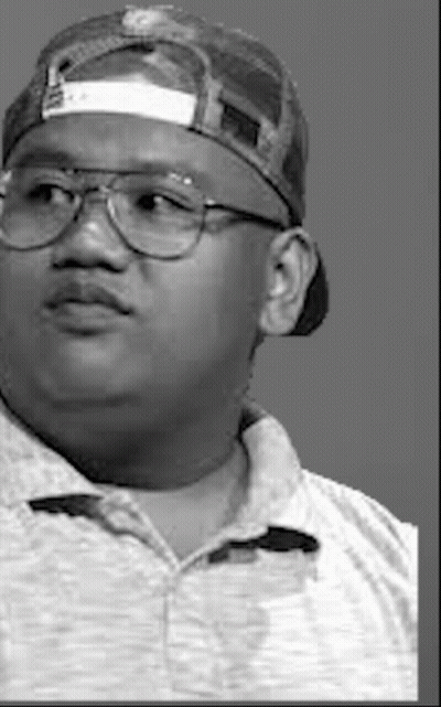 a black and white photo of a man wearing a baseball cap and glasses .