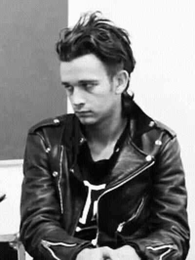 A Black And White Photo Of A Man Wearing A Black Leather Jacket GIF
