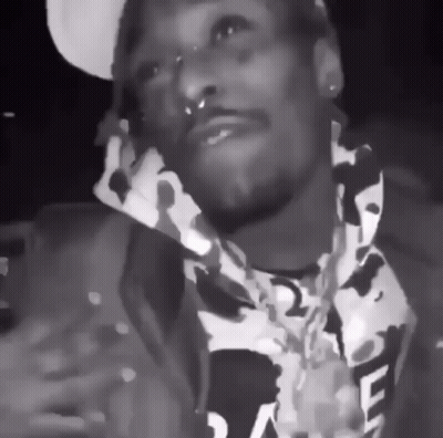 A Black And White Photo Of A Man Wearing A Camo Jacket GIF