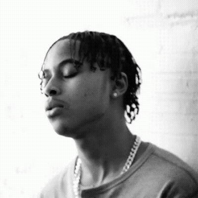 A Black And White Photo Of A Man Wearing A Chain Around His Neck GIF