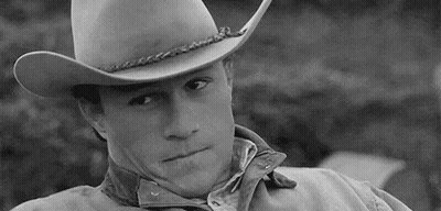 A Black And White Photo Of A Man Wearing A Cowboy Hat And A Bandana . GIF