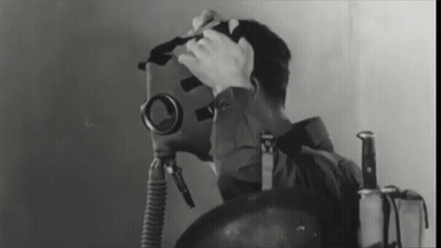 A Black And White Photo Of A Man Wearing A Gas Mask And A Knife GIF