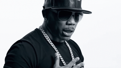 A Black And White Photo Of A Man Wearing A Hat And Chains GIF