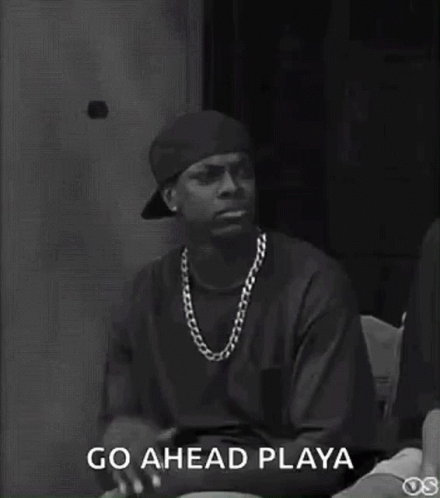 A Black And White Photo Of A Man Wearing A Hat And Necklace . GIF