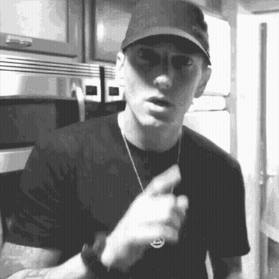 A Black And White Photo Of A Man Wearing A Hat And Sunglasses Pointing . GIF