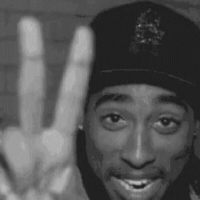 A Black And White Photo Of A Man Wearing A Hat Giving A Peace Sign . GIF