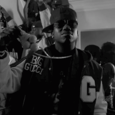 A Black And White Photo Of A Man Wearing A Jacket That Says Big Gucci GIF