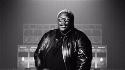 A Black And White Photo Of A Man Wearing A Leather Jacket And Glasses GIF