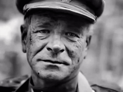A Black And White Photo Of A Man Wearing A Military Uniform GIF