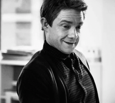 A Black And White Photo Of A Man Wearing A Plaid Shirt And Cardigan GIF