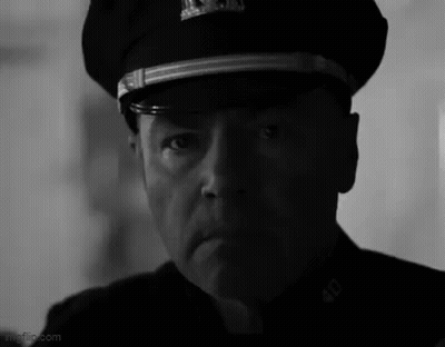 A Black And White Photo Of A Man Wearing A Police Hat . GIF