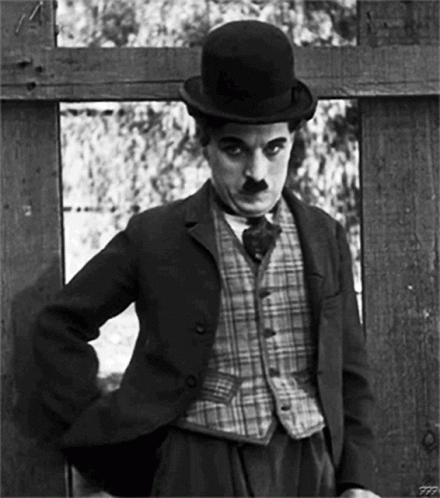 A Black And White Photo Of A Man Wearing A Suit And Top Hat GIF