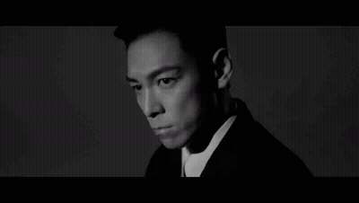 A Black And White Photo Of A Man Wearing A Suit GIF