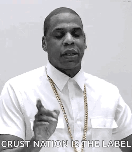A Black And White Photo Of A Man Wearing A White Shirt And Gold Chain Pointing At The Camera . GIF