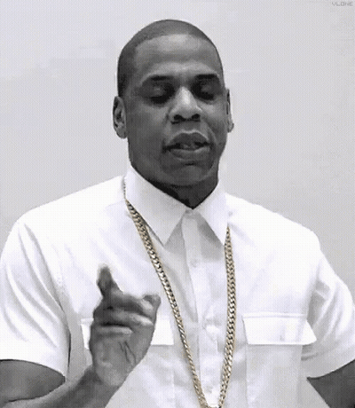 A Black And White Photo Of A Man Wearing A White Shirt And Gold Chain . GIF