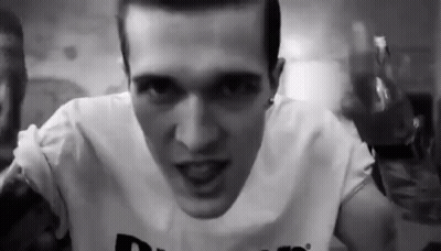 A Black And White Photo Of A Man Wearing A White Shirt . GIF