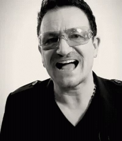 A Black And White Photo Of A Man Wearing Glasses And A Black Shirt . GIF
