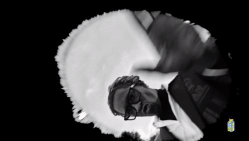 A Black And White Photo Of A Man Wearing Glasses And A Brazil Shirt GIF