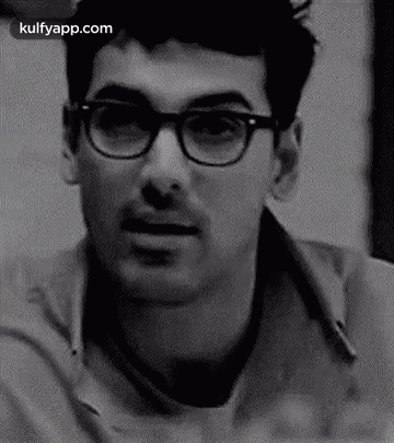 A Black And White Photo Of A Man Wearing Glasses And A Mustache . GIF