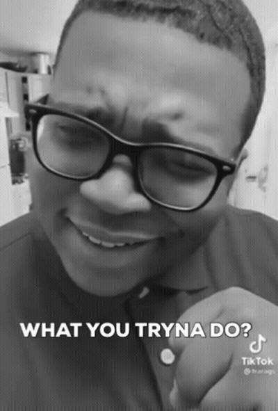 A Black And White Photo Of A Man Wearing Glasses And A Shirt That Says What You Tryna Do GIF