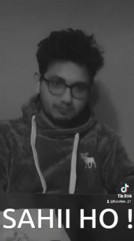 a black and white photo of a man wearing glasses and a sweatshirt that says sahi ho