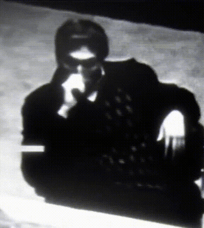 A Black And White Photo Of A Man Wearing Glasses GIF