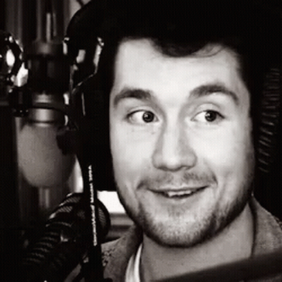 A Black And White Photo Of A Man Wearing Headphones And A Microphone GIF