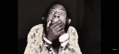 A Black And White Photo Of A Man Wearing Headphones And Covering His Mouth . GIF