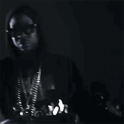 A Black And White Photo Of A Man Wearing Sunglasses And A Hood . GIF