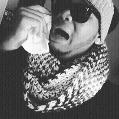 A Black And White Photo Of A Man Wearing Sunglasses And A Scarf Crying GIF