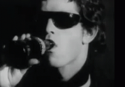 A Black And White Photo Of A Man Wearing Sunglasses And Holding A Coca Cola Bottle GIF