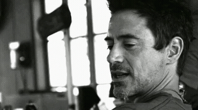 A Black And White Photo Of A Man With A Beard Looking At The Camera . GIF