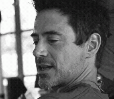 A Black And White Photo Of A Man With A Beard Looking At The Camera . GIF