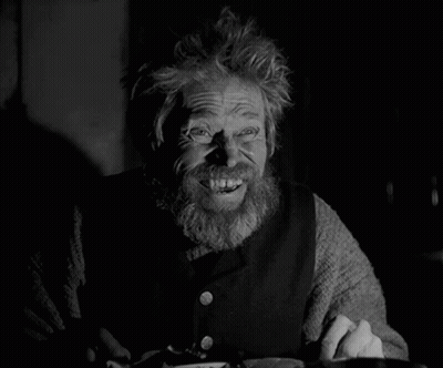 A Black And White Photo Of A Man With A Beard Smiling GIF