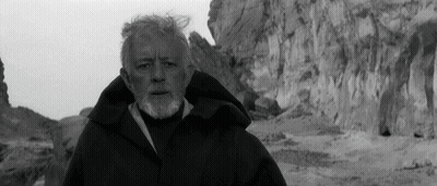 A Black And White Photo Of A Man With A Beard Standing In Front Of A Mountain GIF