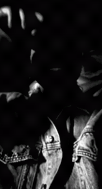 A Black And White Photo Of A Man With A Beard Wearing A Denim Jacket And Sunglasses . GIF