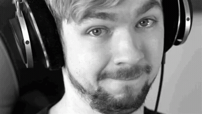 A Black And White Photo Of A Man With A Beard Wearing Headphones And Making A Funny Face . GIF