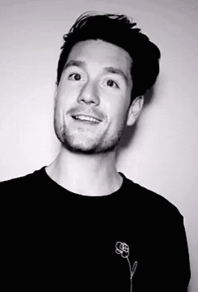 A Black And White Photo Of A Man With A Flower On His Shirt GIF