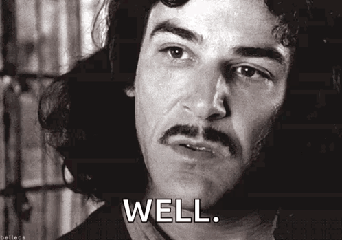 A Black And White Photo Of A Man With A Mustache And The Words `` Well '' Below Him . GIF