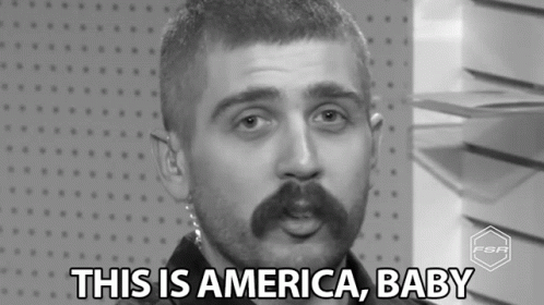 A Black And White Photo Of A Man With A Mustache Saying This Is America Baby . GIF