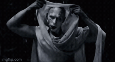 A Black And White Photo Of A Man With A Scarf Around His Neck . GIF