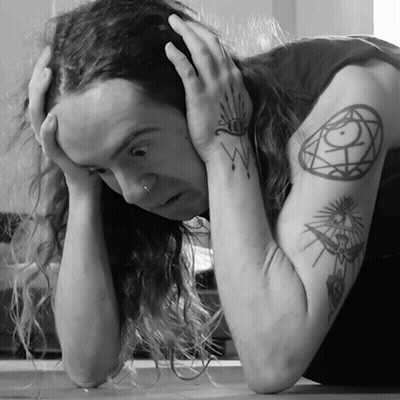 A Black And White Photo Of A Man With A Tattoo On His Arm GIF
