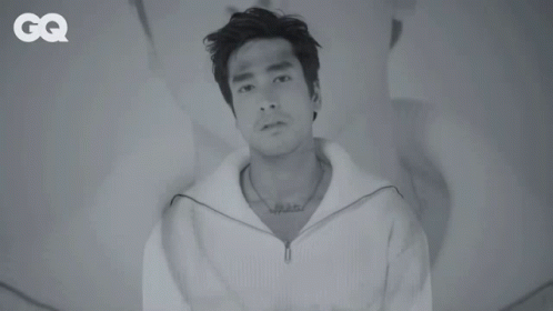A Black And White Photo Of A Man With A Tattoo On His Chest GIF