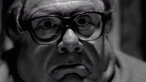 A Black And White Photo Of A Man With Glasses On GIF