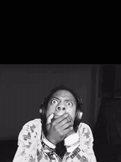 A Black And White Photo Of A Man With Headphones Covering His Mouth With His Hands GIF