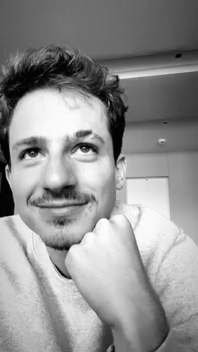 A Black And White Photo Of A Man With His Hand On His Chin Looking Up GIF