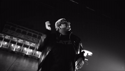 A Black And White Photo Of A Man With His Hands Together GIF