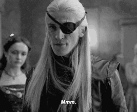 A Black And White Photo Of A Man With Long Hair And A Eye Patch On His Face . GIF