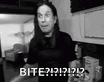 A Black And White Photo Of A Man With Long Hair Making A Funny Face While Standing In A Living Room . GIF